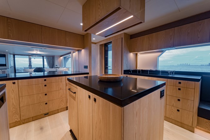 Large galley island with black countertops. 