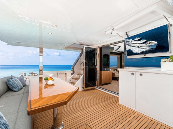 Horizon V68-612 aft deck with seating and teak table.