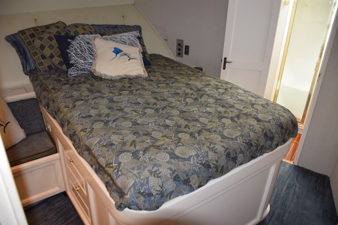 Walkaround queen berth with changing seats on either side of berth  