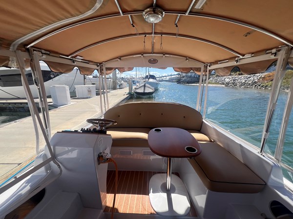 Helm station and movable teak table with drink holders.