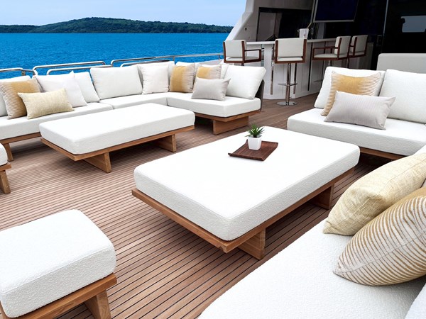 Horizon FD90 Hull 34 Split-use large boat deck with loose loungers and coffee tables and yellow pillows.