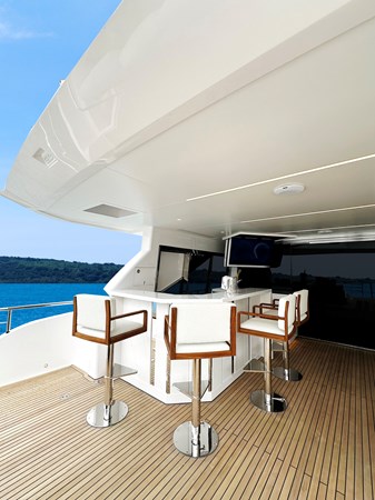 Horizon FD90 Hull 34 Split-use large Skylounge with bar, bar stool and TV.