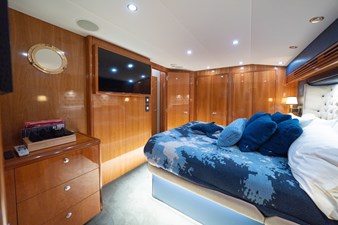 VENTURA 47 Luxurious cabin interior of 2005 Hatteras 60 Convertible yacht with wood paneling and plush bedding.