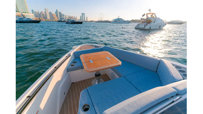ICE 13 Saxdor 400 GTO ICE Bow seating area with teak table on a luxury yacht, overlooking the ocean and nearby yachts in the harbor.