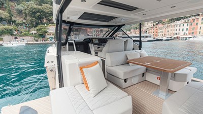 ICE 16 Saxdor 400 GTO ICE cockpit lounge with wraparound seating, wooden dining table, and panoramic Dubai Marina skyline views.