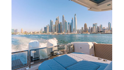 ICE 17 Saxdor 400 GTO ICE Luxury yacht cruising with rear sunpad seating, ocean wake, and city skyline in the background