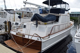 JAMIE LYN 1 1997 Grand Banks Classic yacht docked, featuring elegant wooden details and covered upper deck.