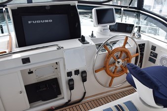 JAMIE LYN 12 1997 Grand Banks Classic helm with wooden wheel, navigation equipment, and Furuno display.