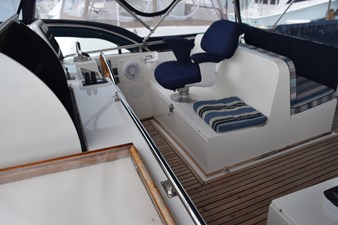 JAMIE LYN 13 Interior of 1997 Grand Banks Classic yacht with blue seating and wooden deck.