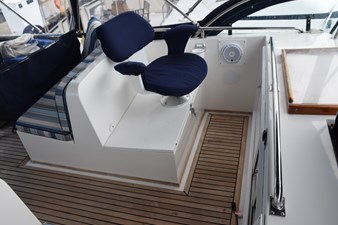 JAMIE LYN 14 1997 Grand Banks Classic boat interior with blue cushioned seating and wooden flooring.