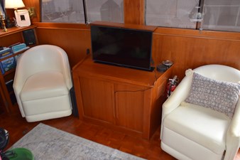 JAMIE LYN 16 Interior of 1997 Grand Banks Classic yacht with chairs, TV, and wooden cabinetry.