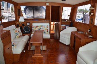 JAMIE LYN 17 Interior of a 1997 Grand Banks Classic yacht with elegant wood finish and floral cushions.