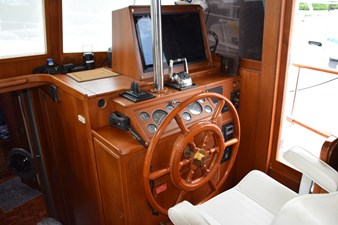 JAMIE LYN 19 1997 Grand Banks Classic yacht helm with wooden steering wheel and navigation instruments.