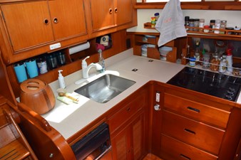 JAMIE LYN 22 1997 Grand Banks Classic yacht kitchen with wooden cabinetry, sink, and stove.