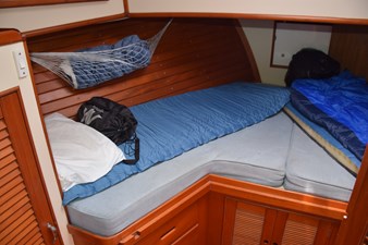 JAMIE LYN 27 Cozy cabin interior of 1997 Grand Banks Classic boat with bedding and storage.