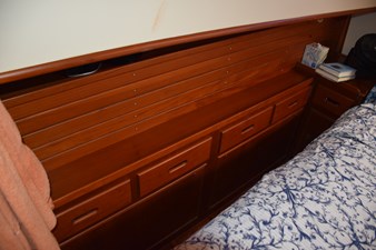 JAMIE LYN 34 Wooden cabinetry in a 1997 Grand Banks Classic boat interior, featuring drawers and a bed.