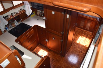 JAMIE LYN 43 Interior of 1997 Grand Banks Classic yacht kitchen with wooden cabinetry and parquet flooring.