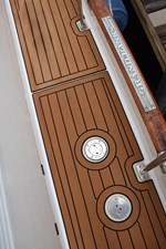 JAMIE LYN 66 1997 Grand Banks Classic boat deck with teak finish and branded metal plate.