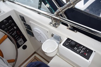 JAMIE LYN 68 1997 Grand Banks Classic boat helm with controls, steering wheel, and cup holder.