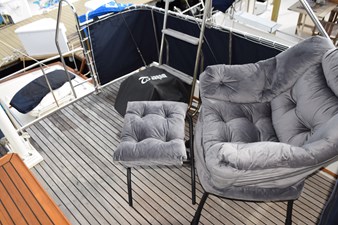 JAMIE LYN 76 Luxury seating on 1997 Grand Banks Classic yacht deck with plush chair and footrest.