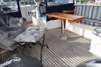 JAMIE LYN 77 1997 Grand Banks Classic yacht interior with cushioned seating and wooden table.