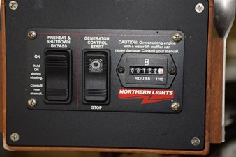 JAMIE LYN 85 1997 Grand Banks Classic generator control panel with hour meter and caution label.