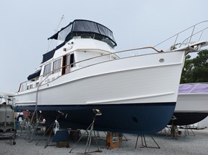 JAMIE LYN 94 1997 Grand Banks Classic yacht on stands, white hull with blue bottom, in a boatyard.
