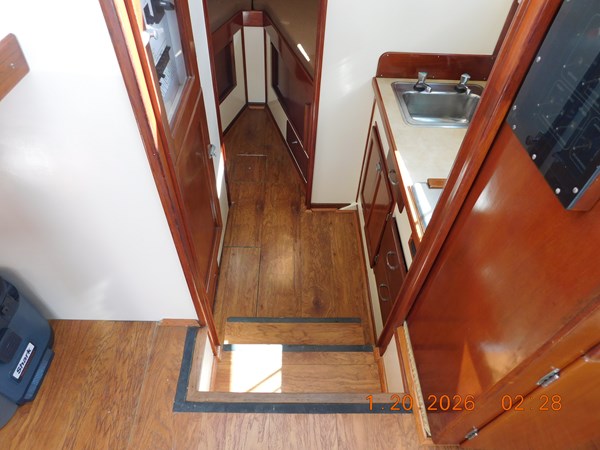 Steps down to galley, head, and berth. Laminate wood flooring.