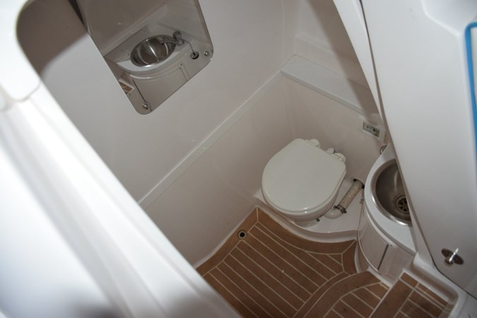 Raritan electric head, stainless steel sink with faucet, shower wand, and drained sole with SeaDek, mirror.