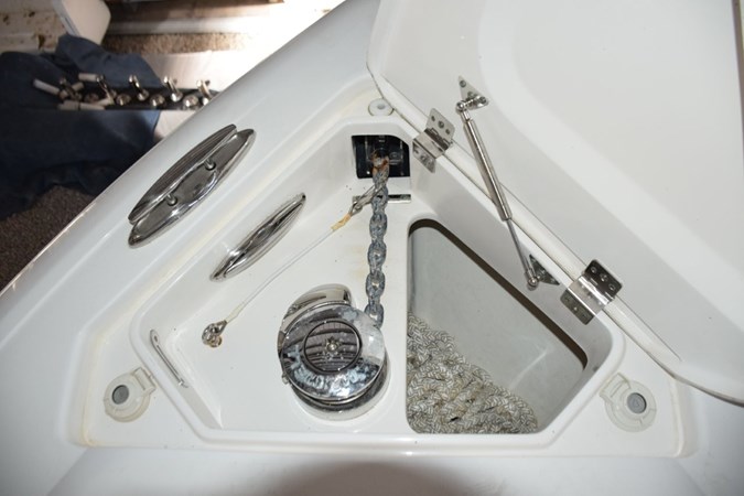 Electric anchor windlass with safety lanyard and thru-hull chute - stainless claw anchor, chain lead and nylon rode. Switches here