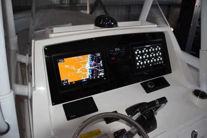 Magnetic compass on top of helm, Fusion stereo to starboard.