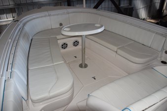 Forward seating and fiberglass table with drink holders. Storage compartments behind backrests.