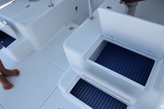 Storage compartments behind helm seat
