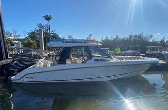UNPLUGGED 0 2023 Boston Whaler 350 Realm boat docked in a sunny marina setting.