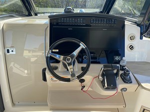 UNPLUGGED 3 Cockpit of 2023 Boston Whaler 350 Realm with steering wheel and control panel.