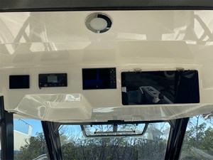 UNPLUGGED 5 2023 Boston Whaler 350 Realm dashboard with electronic controls and storage compartments.