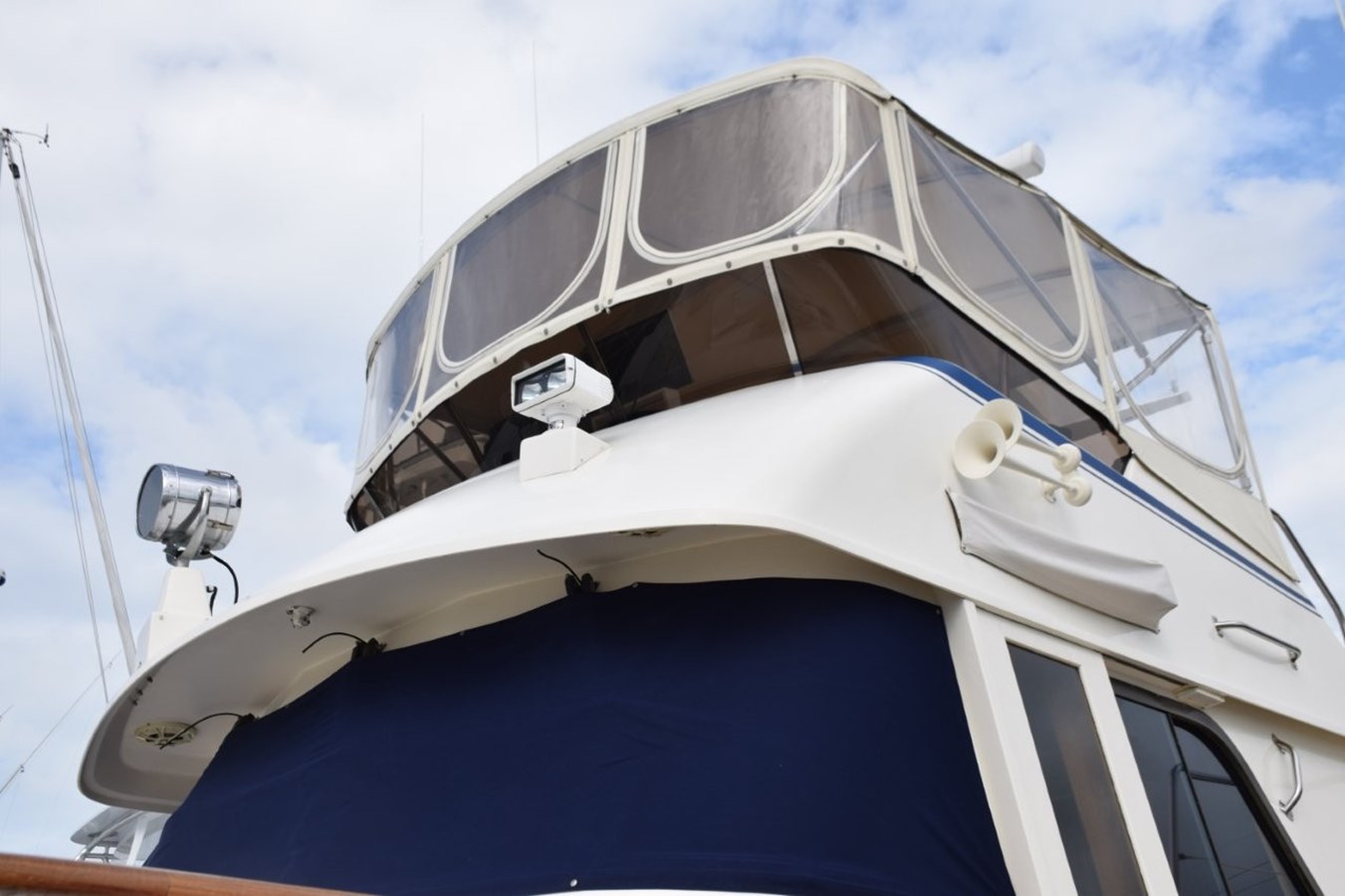 Navy Sunbrella canvas windshield mask, name board covers, and 3-sided flybridge enclosure with U-Zips