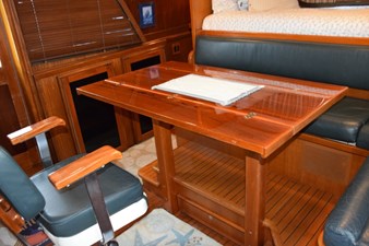 Pilothouse table expanded and helm chair turned