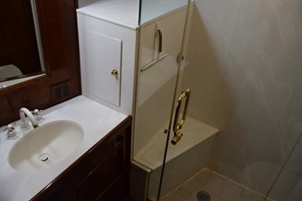 Master vanity top with mirrored medicine cabinet and glass shower enclosure with seat